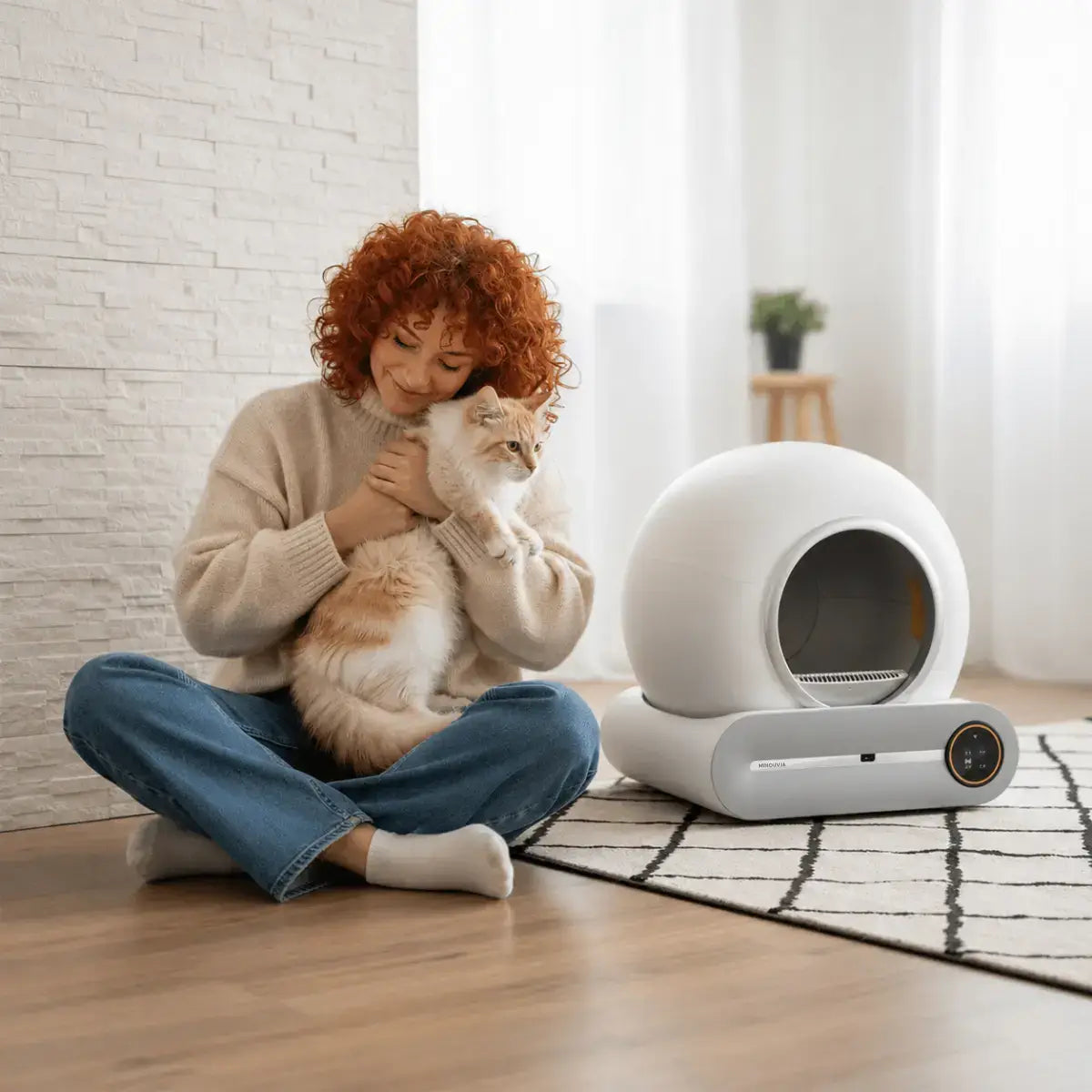 femme câlinant son chat à côté d'une Litière Automatique Autonettoyante pour Chat